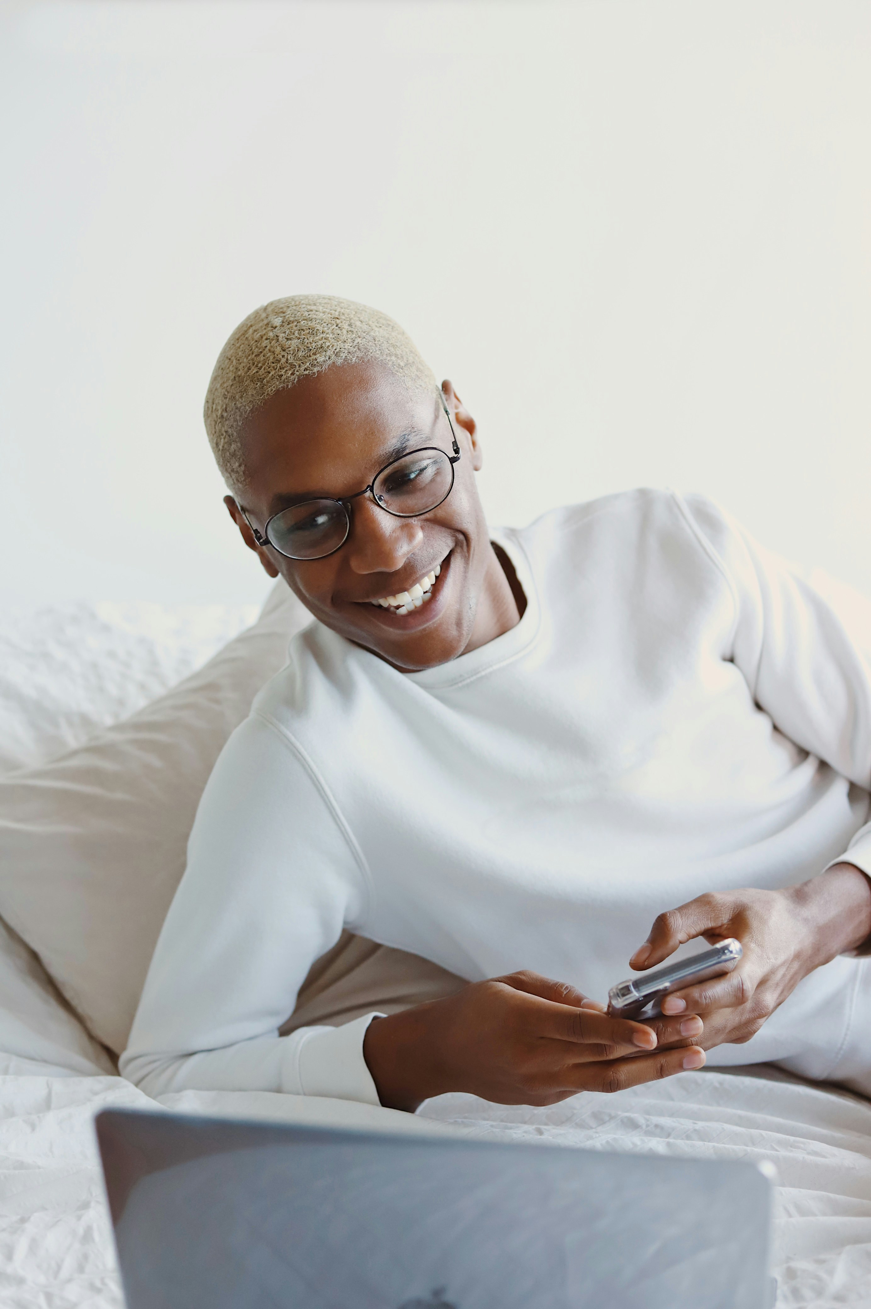 man in white turtleneck sweater holding smartphone